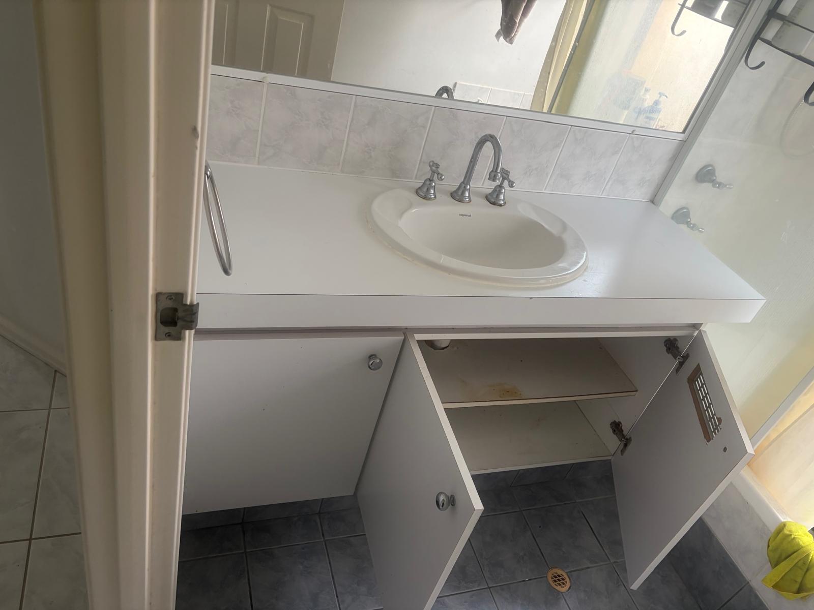 Old, worn bathroom vanity before replacement